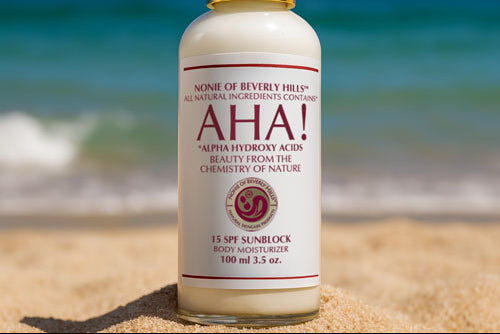 Nonie of Beverly Hills AHA 15 spf sunblock moisturizer in 3.5 oz glass bottle sitting on sand on the beach with ocean in the background